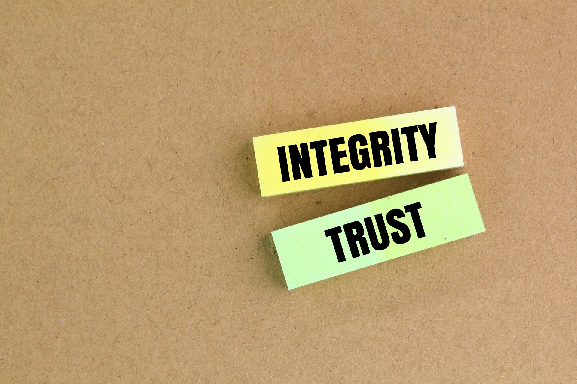 colored paper with the words integrity and trust. the concept of trusting someone or being given trust